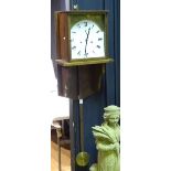 A large oak wall clock, with weight and pendulum,