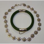 A green jade coloured bangle, with gold plated mounts, together with a silver daisy necklace,