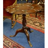 A Georgian mahogany snap action supper table, featuring eight circular mahogany plate apertures,