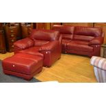A contemporary red leather two seater sofa with matching armchair and stool,