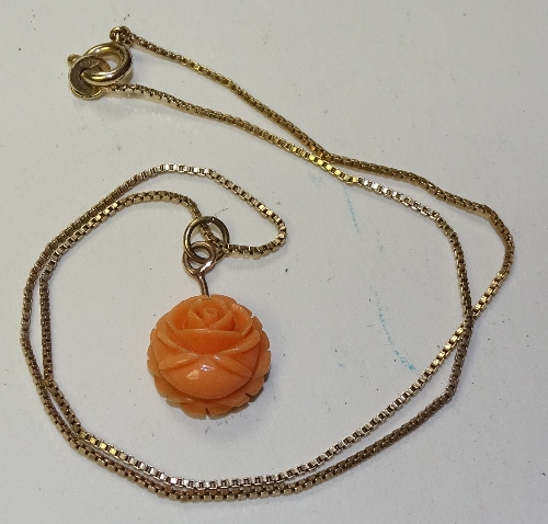 A child's 9ct gold and coral rose pendant, stamped 9ct to back of rose and clasp, 31.