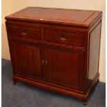 A Chinese hardwood cupboard chest, with two small drawers above two panelled doors,