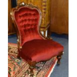 A Victorian mahogany framed gent's parlour armchair, upholstered in later red buttonback velour,