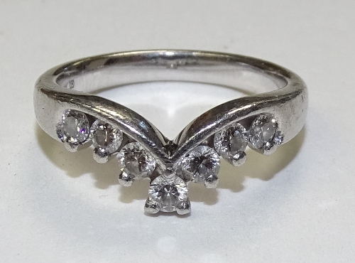 A platinum seven stone diamond wishbone ring, the round brilliant cut diamonds totalling 0.