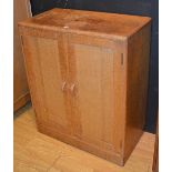 A small Art Deco light oak cupboard by Heals of London circa 1920/30's, with two panelled doors,