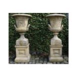 PAIR OF LARGE PORTLAND STONE URNS AND BASES in the manner of Thomas Hope 110 cm. high; 65 cm.