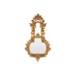 LATE EIGHTEENTH-CENTURY CHIPPENDALE CARVED GILTWOOD MIRROR within a stylized banjo shaped frame,