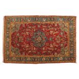 EARLY TWENTIETH-CENTURY PERSIAN SILK AND WOOL RUG on red ground, with central medallion, and