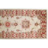 NORTH WEST PERSIAN RUNNERon ivory ground with numerous medallions and red border402 x 84 cm.