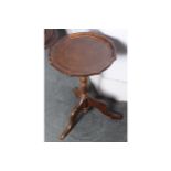 MODERN WINE TABLE the circular serpentine shaped top, raised on a turned stem and scroll legged