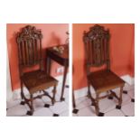 PAIR OF NINETEENTH-CENTURY CARVED OAK ARMORIAL HALL CHAIRS each with a railed and leaf carved