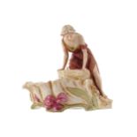 ROYAL DUX FIGUREof a girl seated at a well27 cm. high; 29 cm. wide