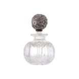 SILVER AND CRYSTAL PERFUME DECANTERof bulbous form. The stopper richly embossed with raised floral