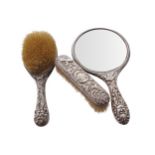 THREE PIECE SILVER BACKED VANITY SETwith rich embossed leaf scroll ornithological and mask