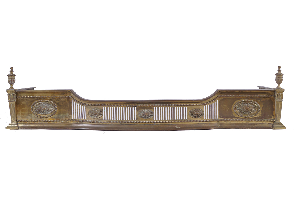 EDWARDIAN BRASS NEO-CLASSICAL FIRE FENDER the pierced breakfront flanked by paterae panels