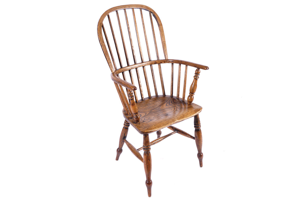 NINETEENTH CENTURY ELM COMB-BACK WINDSOR CHAIR with a panelled seat, raised on out swept turned legs