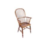 NINETEENTH CENTURY ELM COMB-BACK WINDSOR CHAIR with a panelled seat, raised on out swept turned legs
