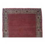 GHASHGHAEI RUG the central red field a maze of floral bows, within a cream floral decorated outer