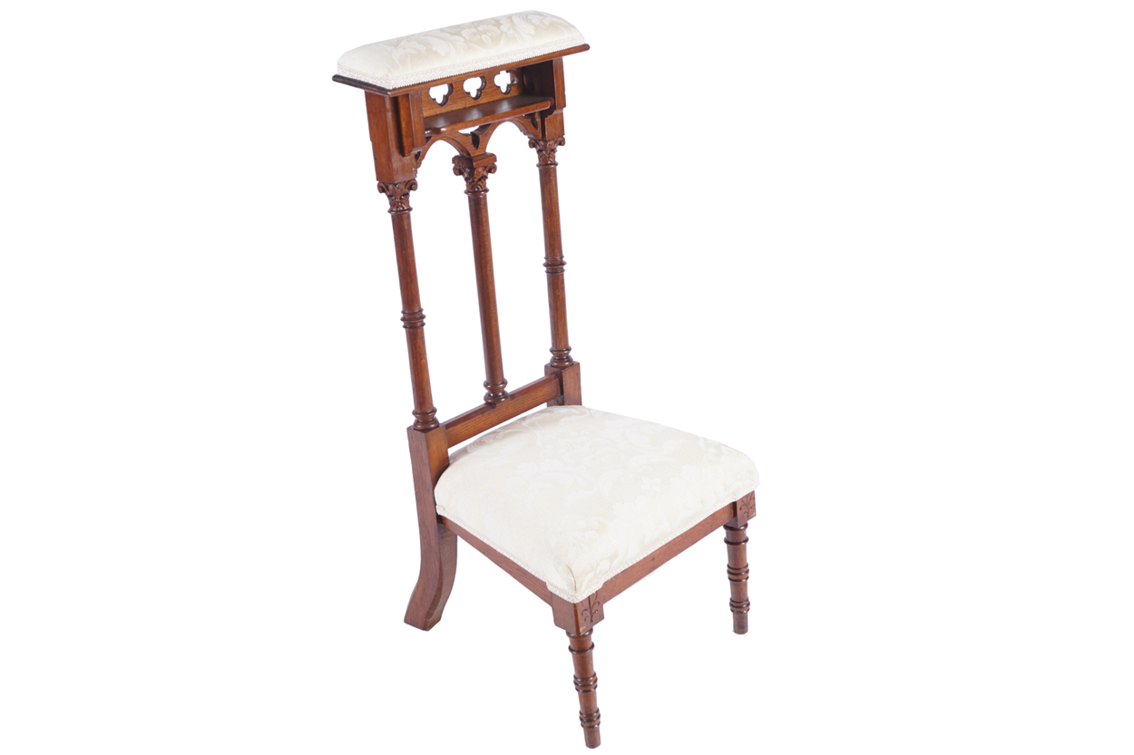 PRIE-DIEU CHAIR the cushioned arm rest above a gothic double arched pierced back above an