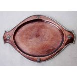 A late 19th century planished copper tray of two handled , dished oval form with white metal