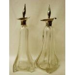 A pair of late 19th century Art Nouveau glass Decanters of pear shape, four footed with silver