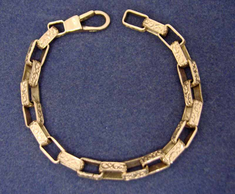 A 9ct gold chain bracelet of box link form, each link scroll decorated, 20cm long, 22.4g