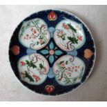 A Japanese Imari Plate, decorated with panels of flowering foliage on blue ground with interspacing,