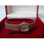 A ladies 9ct gold Omega Wrist Watch, silvered rectangular face with baton markers, signed Omega