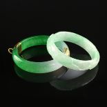 A GROUP OF TWO CHINESE JADEITE JADE BANGLES, MODERN, comprising an apple green bangle with a rounded