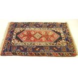 A Turkoman style rug with geometric motifs on a blue and faded pale ground 180 x 118cm