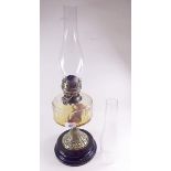 A Victorian oil lamp with brass heart embossed base
