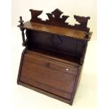 An Edwardian mahogany small cabinet with slope front and raised back