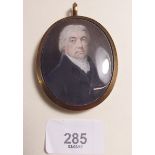 A Victorian miniature portrait of a gentleman in yellow metal and enamel frame with hair locket to