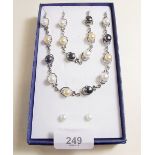 A silver pearl and black pearl necklace and bracelet and earrings set