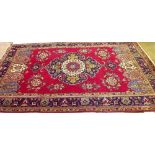 A red ground Persian Tabriz carpet with vibrant colour medallion design 2m x 3m