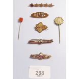 Five various brooches and two stick pins