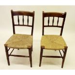 A pair of Edwardian spindle back rush seated chairs and another spindle back chair