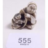 A Japanese Meiji period ivory netsuke carved seated woman with child in a basket, signed to base