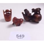 A Japanese carved netsuke of dogs and two smaller netsuke