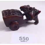 A carved and signed netsuke depicting a rat pushing a barrow
