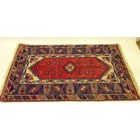 A Turkoman style rug with geometric motifs on a blue and red ground 190 x 119cm