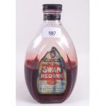 A large early 20th century Swan red ink glass bottle and contents