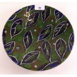 An Art Pottery plate decorated leaves by Janice Tokolenka - 24cm dia