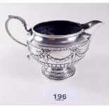 A silver cream jug with embossed swags, London 1885 by John Aldwinckle & Thomas Slater