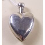 A small silver heart shaped perfume bottle