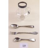 A silver rimmed small glass jug, a pickle fork, mustard spoon and teaspoon