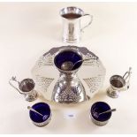 A silver plated cake stand, salts, egg cups, tankard and sugar