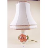 A Moorcroft small table lamp painted in the hibiscus pattern on a cream ground