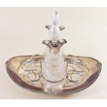 An Edwardian silver boat form liqueur decanter stand with two cut glass and silver mounted decanters