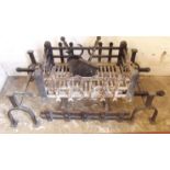 A large antique cast iron fire grate and dogs